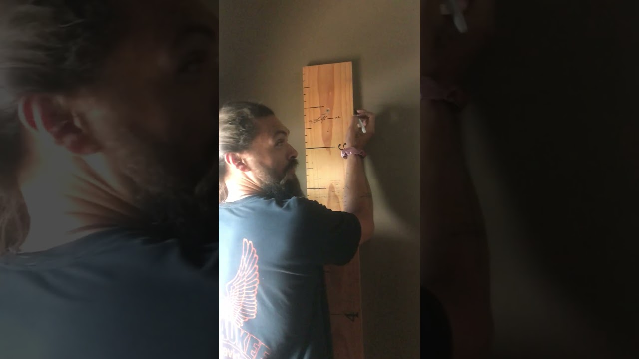 Jason Momoa at our house getting measured on our family height chart.